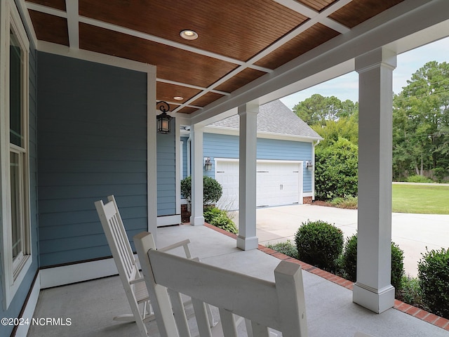 view of patio featuring a porch and a garage