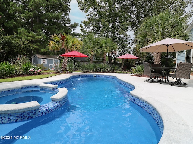 view of pool with a patio, an in ground hot tub, and a shed