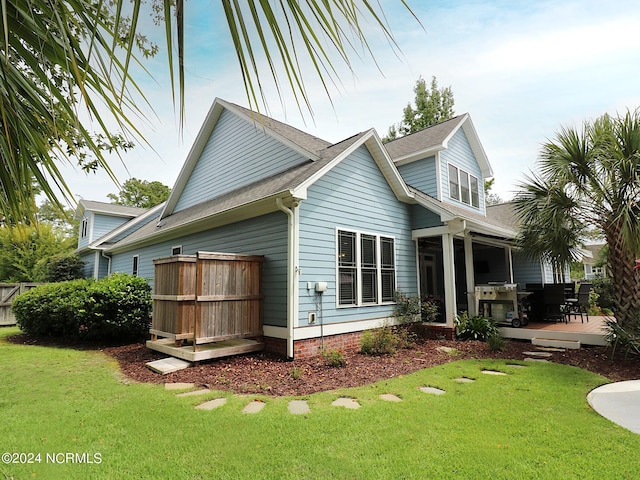 back of property featuring a lawn and a patio