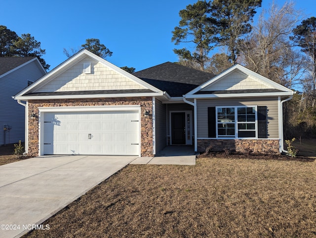 craftsman-style house featuring an attached garage, stone siding, and driveway