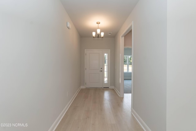 doorway featuring light hardwood / wood-style flooring and a chandelier