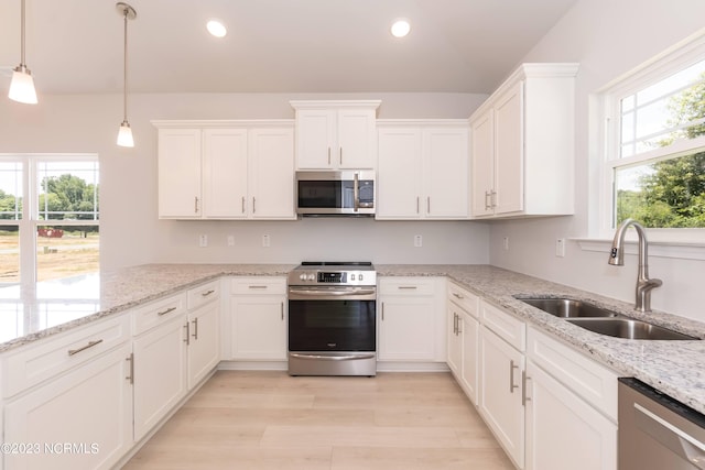 kitchen featuring sink, white cabinetry, appliances with stainless steel finishes, and light stone countertops