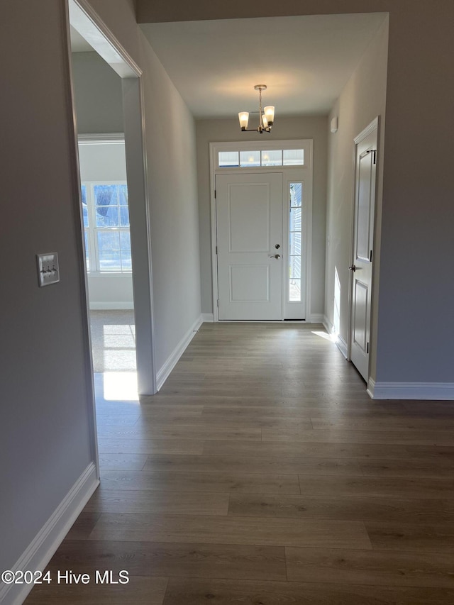 foyer entrance featuring a chandelier and dark wood-type flooring