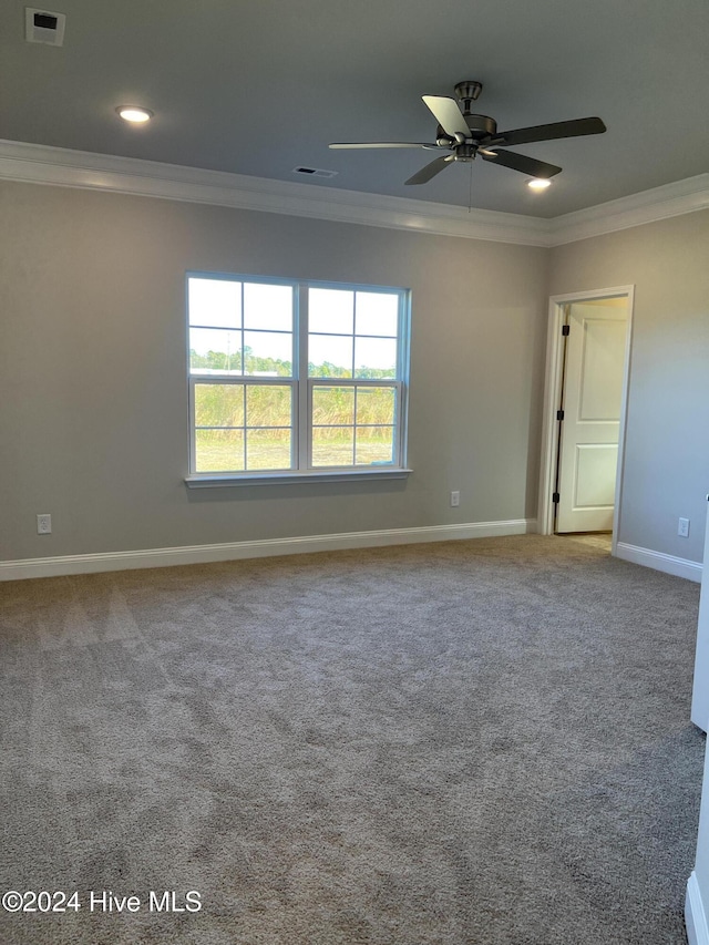 empty room featuring carpet floors, ornamental molding, and ceiling fan