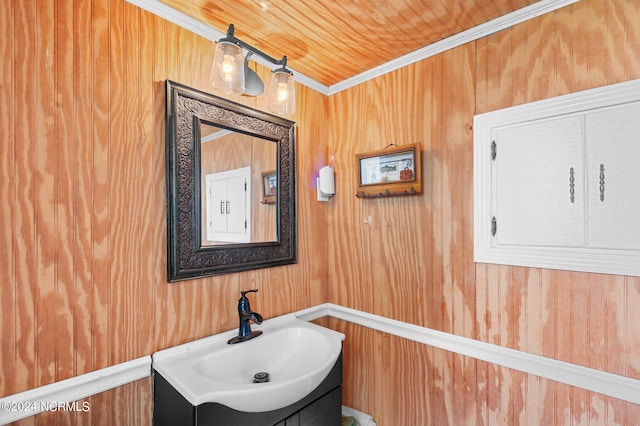 bathroom featuring ornamental molding, vanity, wooden walls, and wood ceiling