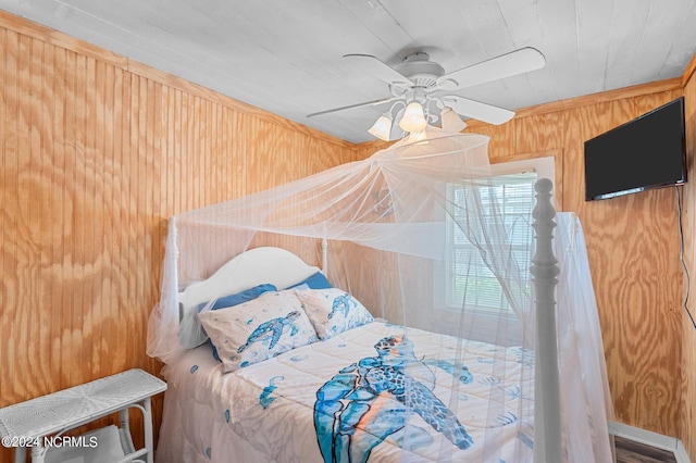 bedroom featuring wood walls and a ceiling fan