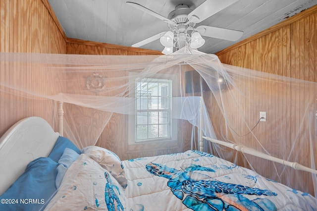 bedroom featuring a ceiling fan and wooden walls