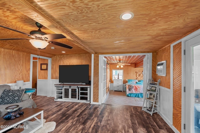 unfurnished living room with dark wood-type flooring, wood walls, ceiling fan, and wooden ceiling