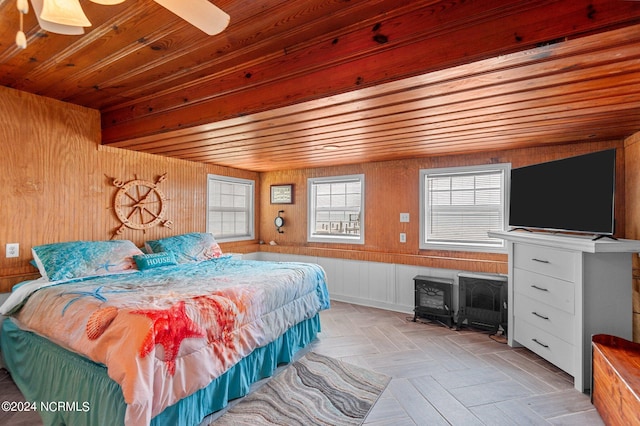 bedroom featuring wooden ceiling, light parquet floors, ceiling fan, and wooden walls