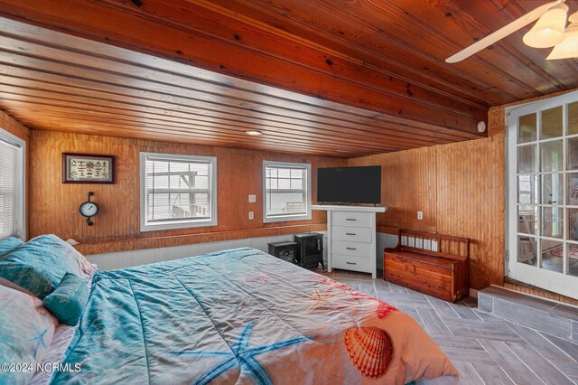 bedroom with light parquet floors, ceiling fan, wooden walls, and wooden ceiling