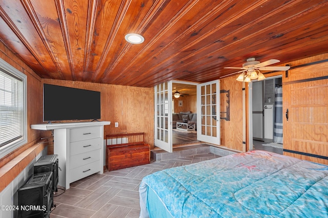 bedroom featuring wood ceiling, french doors, wood walls, and ceiling fan