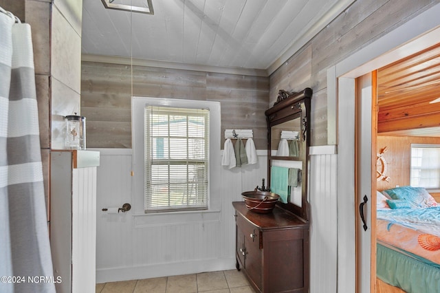 bathroom featuring a healthy amount of sunlight and wooden walls