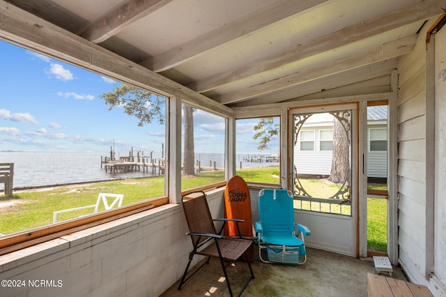 sunroom / solarium with a water view, a wealth of natural light, and lofted ceiling with beams