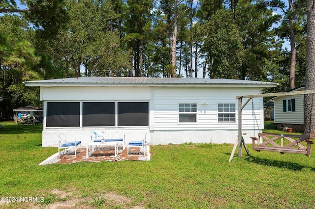 rear view of property with metal roof and a yard