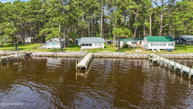 view of dock with a water view and a lawn