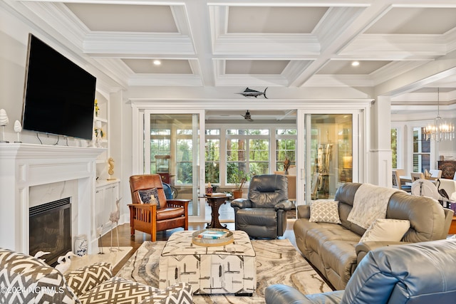 living room with a chandelier, coffered ceiling, beamed ceiling, and a high end fireplace