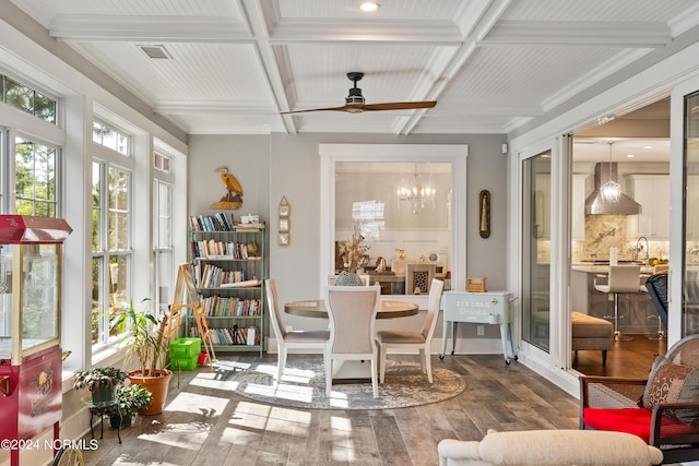 sunroom with beam ceiling, coffered ceiling, visible vents, and ceiling fan with notable chandelier