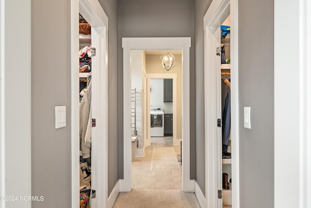 hall featuring washer / clothes dryer and light carpet