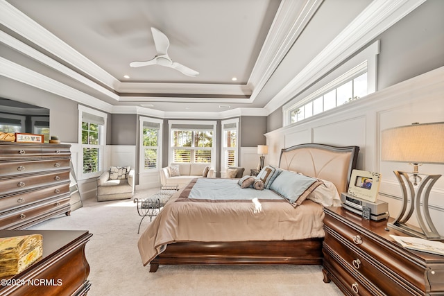 bedroom featuring a wainscoted wall, a decorative wall, multiple windows, and light colored carpet