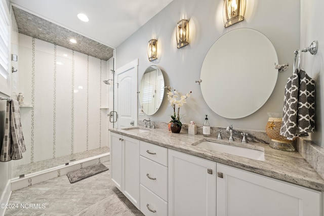 bathroom with double vanity, a shower stall, and a sink