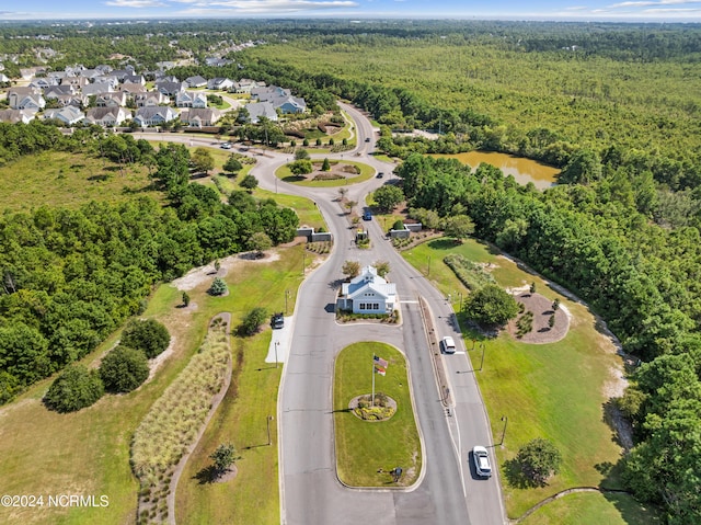 drone / aerial view with a residential view, a water view, and a forest view