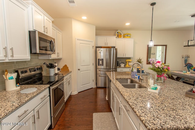 kitchen featuring decorative backsplash, dark hardwood / wood-style floors, hanging light fixtures, sink, and stainless steel appliances