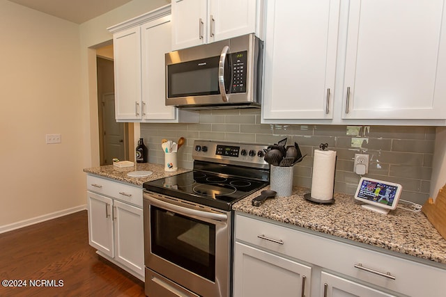 kitchen featuring dark hardwood / wood-style flooring, appliances with stainless steel finishes, light stone counters, tasteful backsplash, and white cabinets