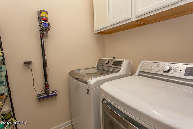 laundry room with washing machine and dryer and cabinets