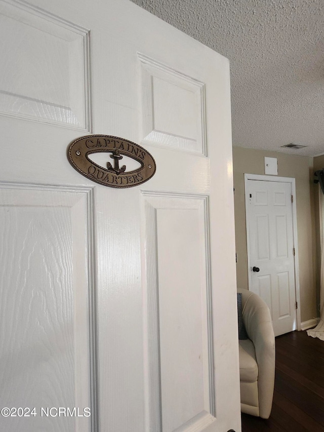 interior details featuring a textured ceiling and hardwood / wood-style floors