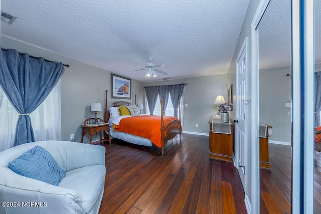 bedroom with ceiling fan, a textured ceiling, and dark hardwood / wood-style flooring