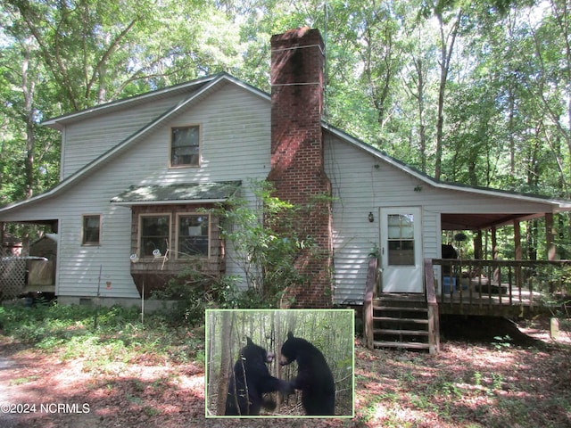 rear view of property featuring a wooden deck