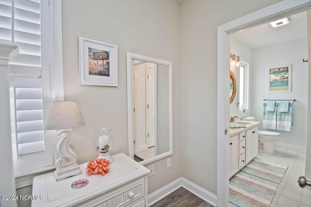 bathroom featuring vanity, toilet, and baseboards