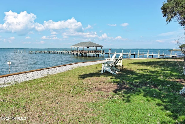 view of dock featuring a water view and a yard