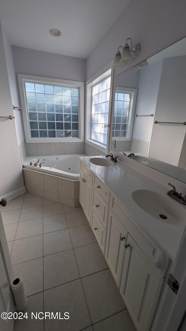 bathroom with a whirlpool tub, double vanity, a sink, and tile patterned floors