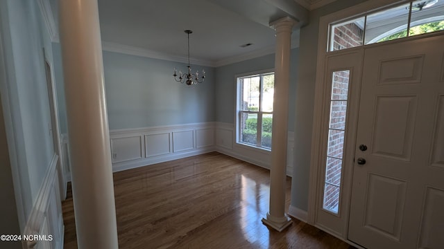 foyer featuring ornamental molding, a chandelier, ornate columns, and dark hardwood / wood-style floors