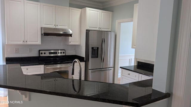 kitchen featuring dark stone countertops, appliances with stainless steel finishes, white cabinetry, kitchen peninsula, and decorative backsplash