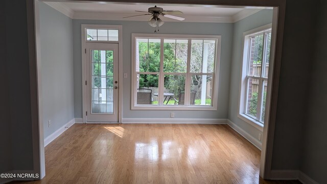 entryway with light wood-type flooring, crown molding, and ceiling fan