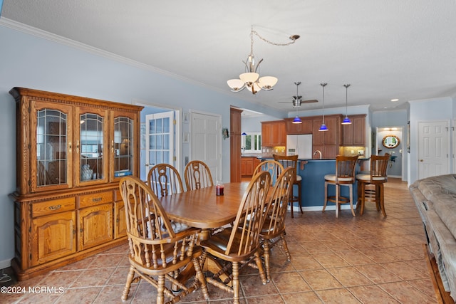 dining room with ornamental molding, a textured ceiling, light tile patterned floors, and sink