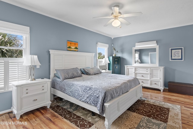 bedroom with ceiling fan, ornamental molding, and light hardwood / wood-style floors