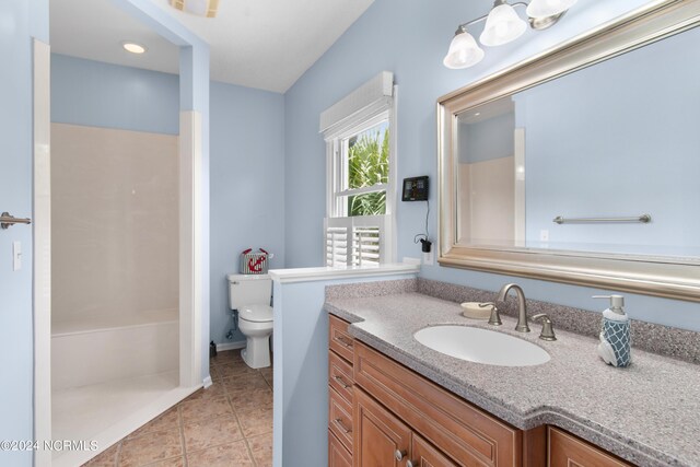 bathroom with a shower, tile patterned flooring, vanity, and toilet