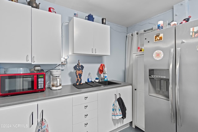 kitchen with stainless steel refrigerator with ice dispenser and white cabinetry