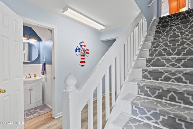 stairway featuring hardwood / wood-style flooring and sink