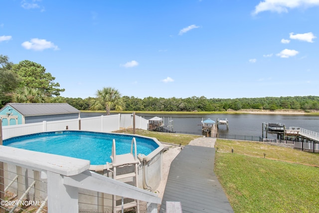 view of swimming pool with a boat dock, a lawn, and a water view