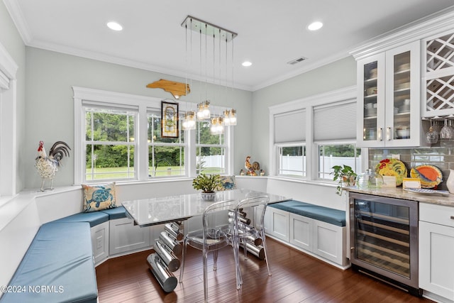 dining space featuring crown molding, breakfast area, beverage cooler, and dark hardwood / wood-style floors