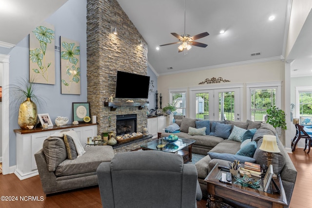 living room featuring dark hardwood / wood-style floors, a stone fireplace, a wealth of natural light, and ornamental molding