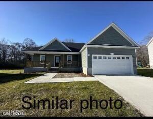 view of front of house featuring a front lawn, a porch, and a garage