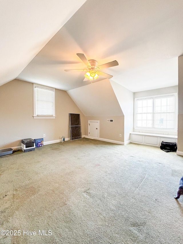 additional living space with vaulted ceiling, a ceiling fan, baseboards, and carpet floors