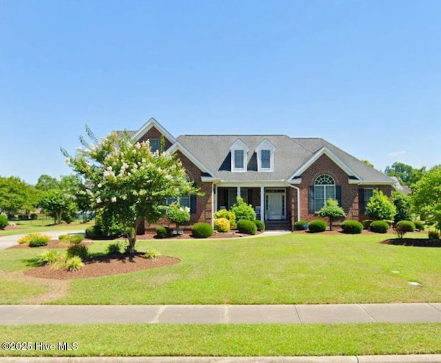 view of front facade with brick siding and a front lawn