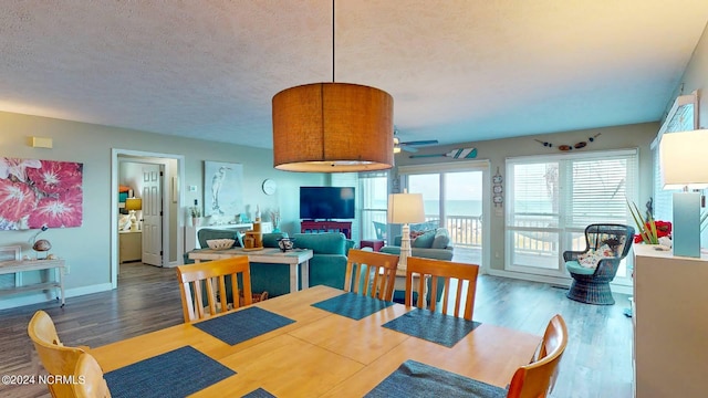 dining room featuring ceiling fan, dark hardwood / wood-style flooring, and a textured ceiling