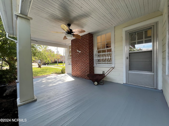 wooden terrace featuring covered porch and ceiling fan